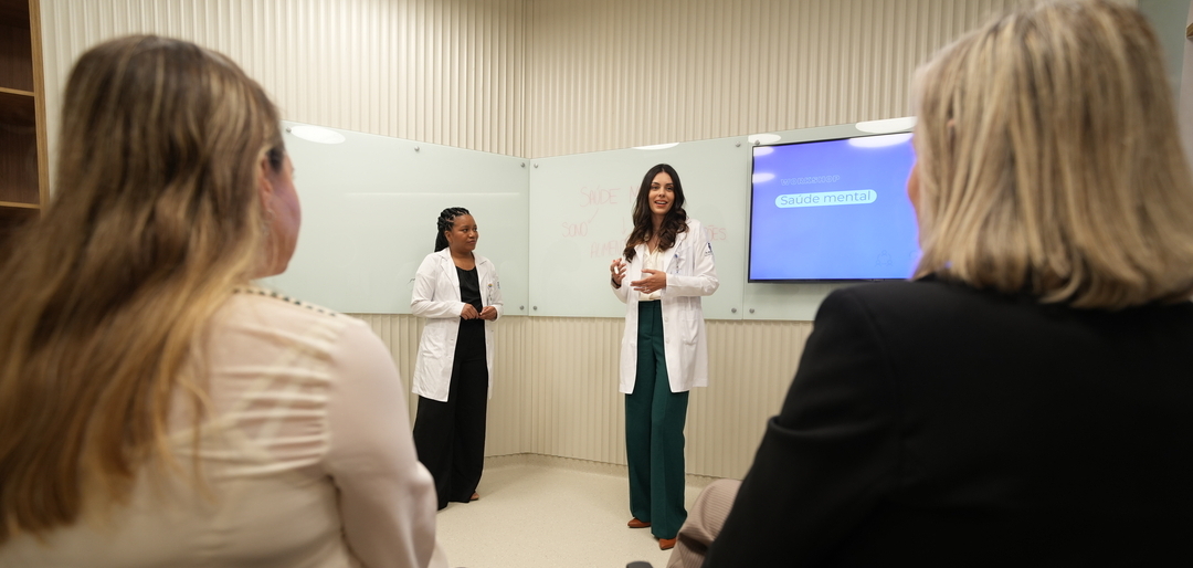 Duas profissionais em apresentação para público sobre liderança e a saúde mental