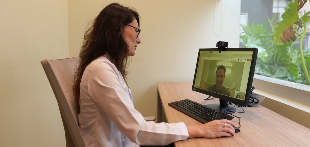 Sessão de telepsicologia, com psicóloga em vídeo-consulta atendendo paciente pelo computador